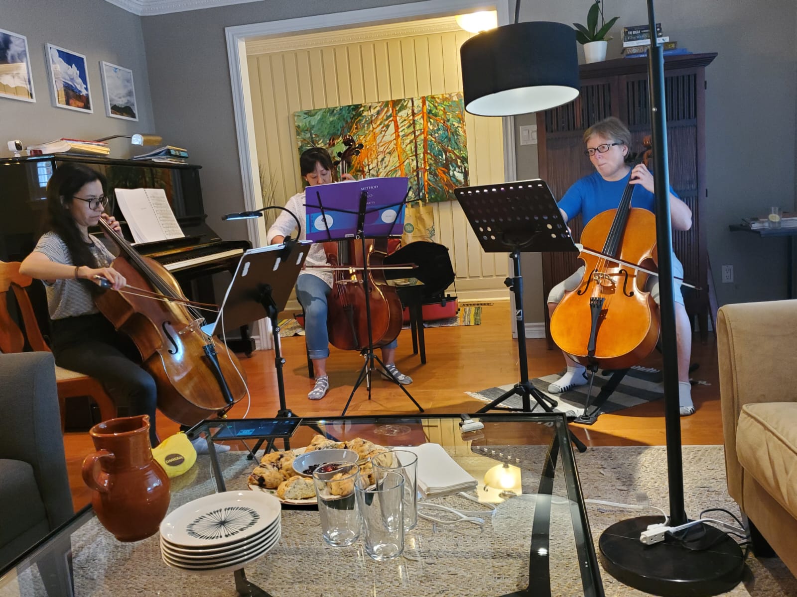 Three musicians rehearsing together in a warm living-room recital space
