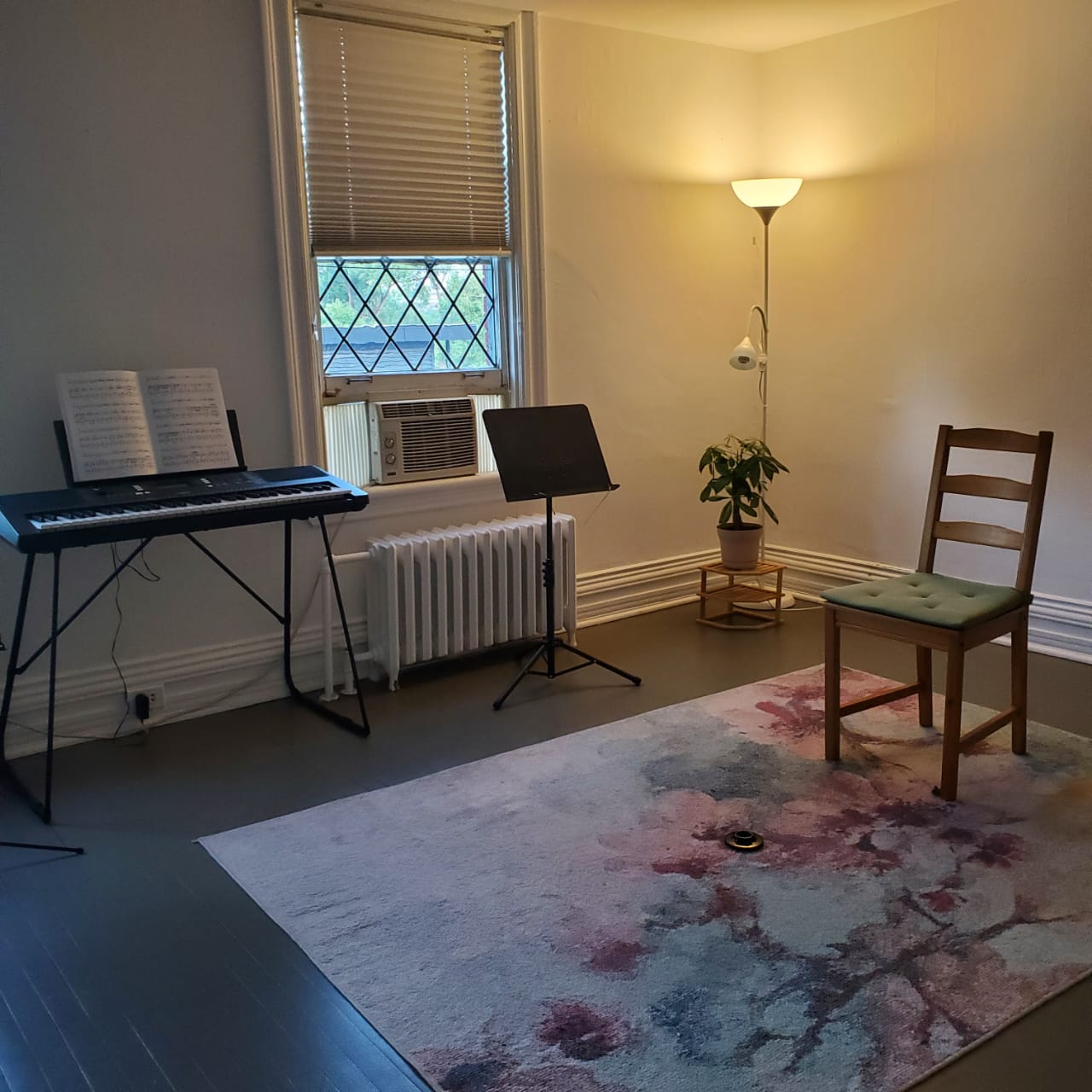 Practice room with keyboard, sheet music, and reading lamp