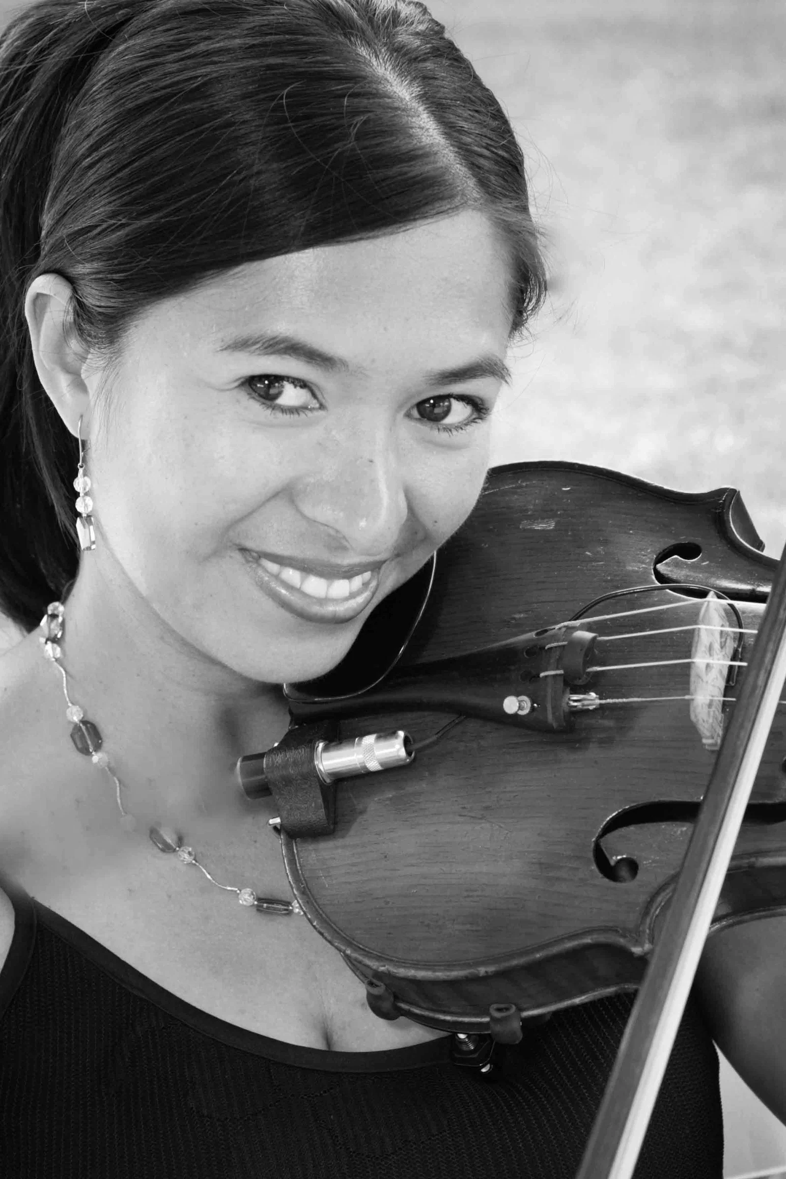 Black and white close-up portrait of Marlene Cruz Lozano playing violin