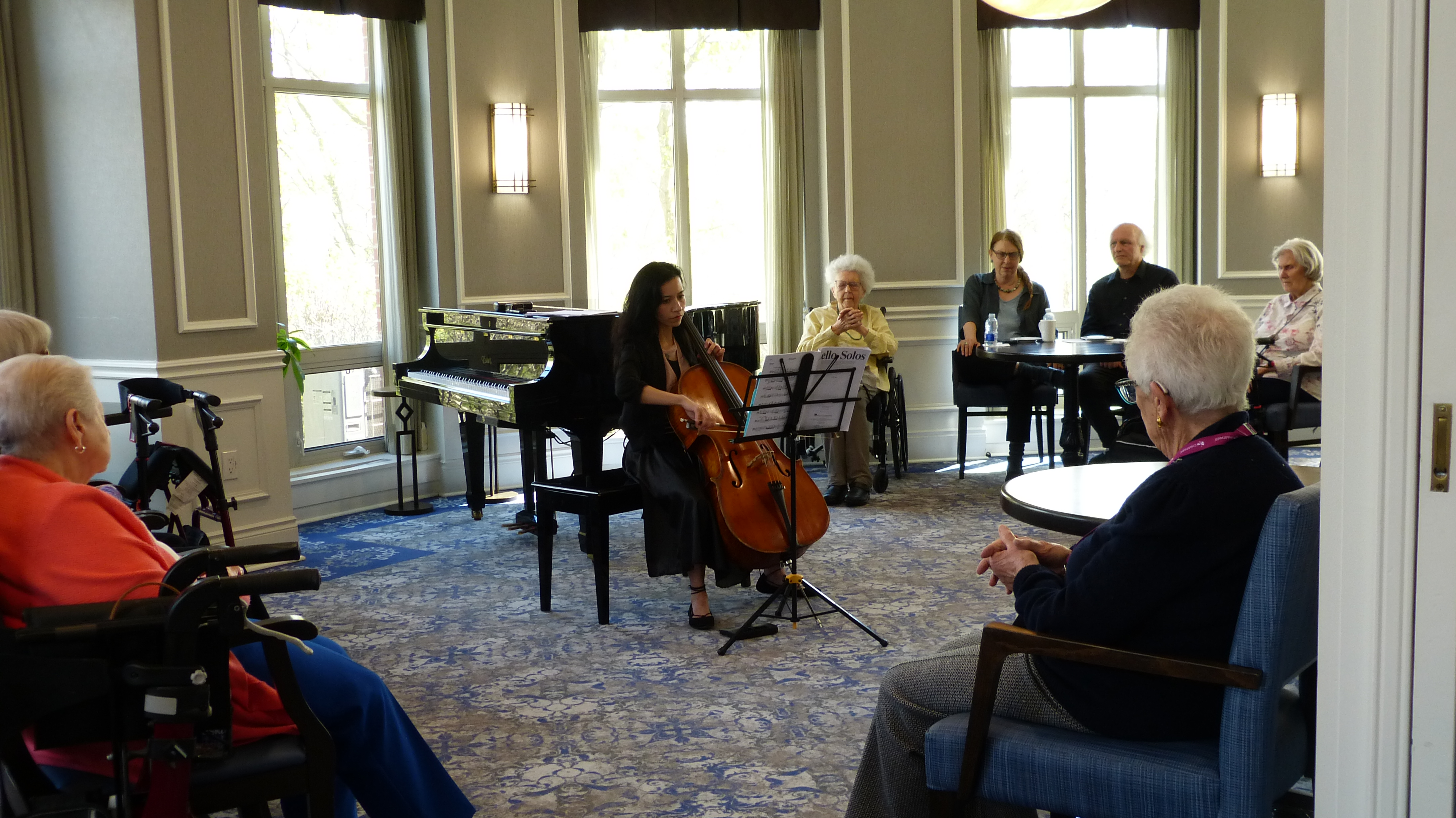 Student performing cello for a community audience